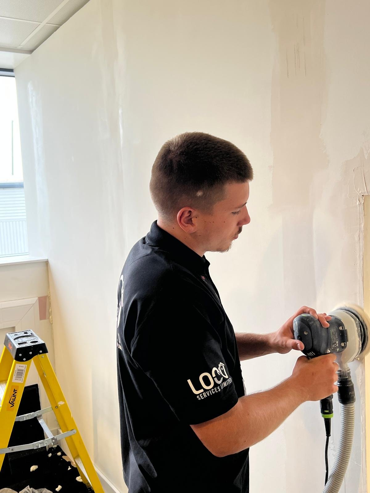 LOCO team member preparing a wall for decorating